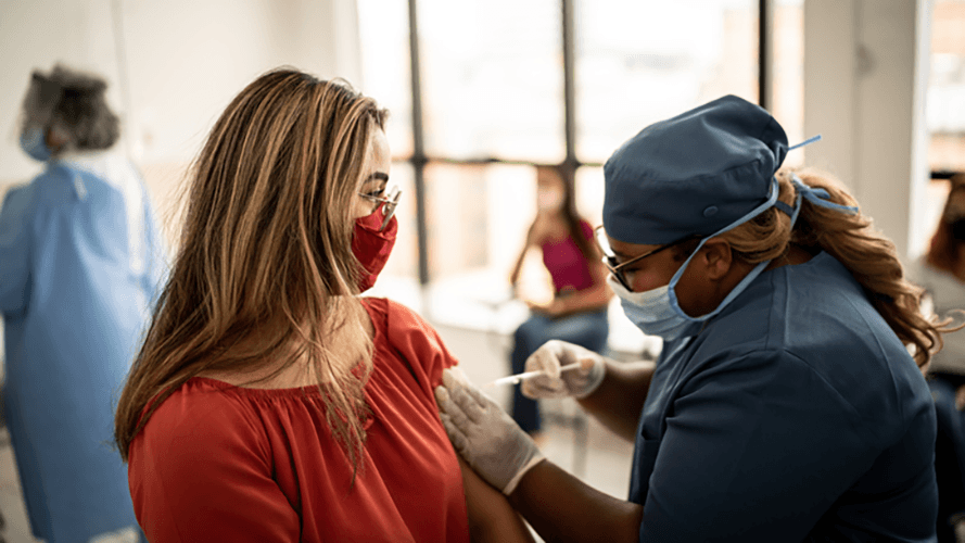 mujer recibe la vacuna contra la gripe