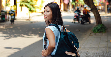 joven asiática con una mochila caminando por la calle