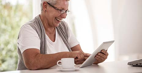 adultos mayores felices miran una tableta en casa