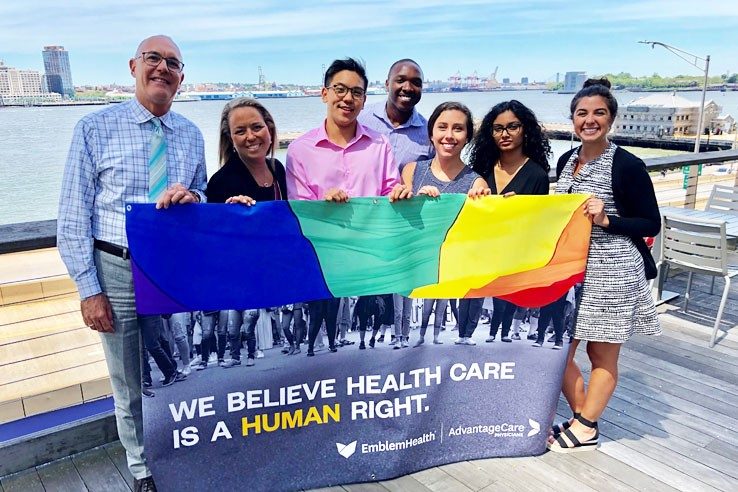 Líderes y aliados de Prism mostrando nuestra pancarta del Orgullo 2019 en Water Street