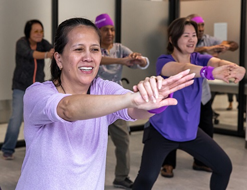 Hombres y mujeres participan en una clase de fitness en una ubicación de Neighborhood Care.
