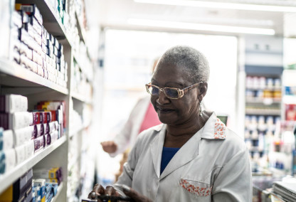 Mujer farmacéutica mayor mirando recetas