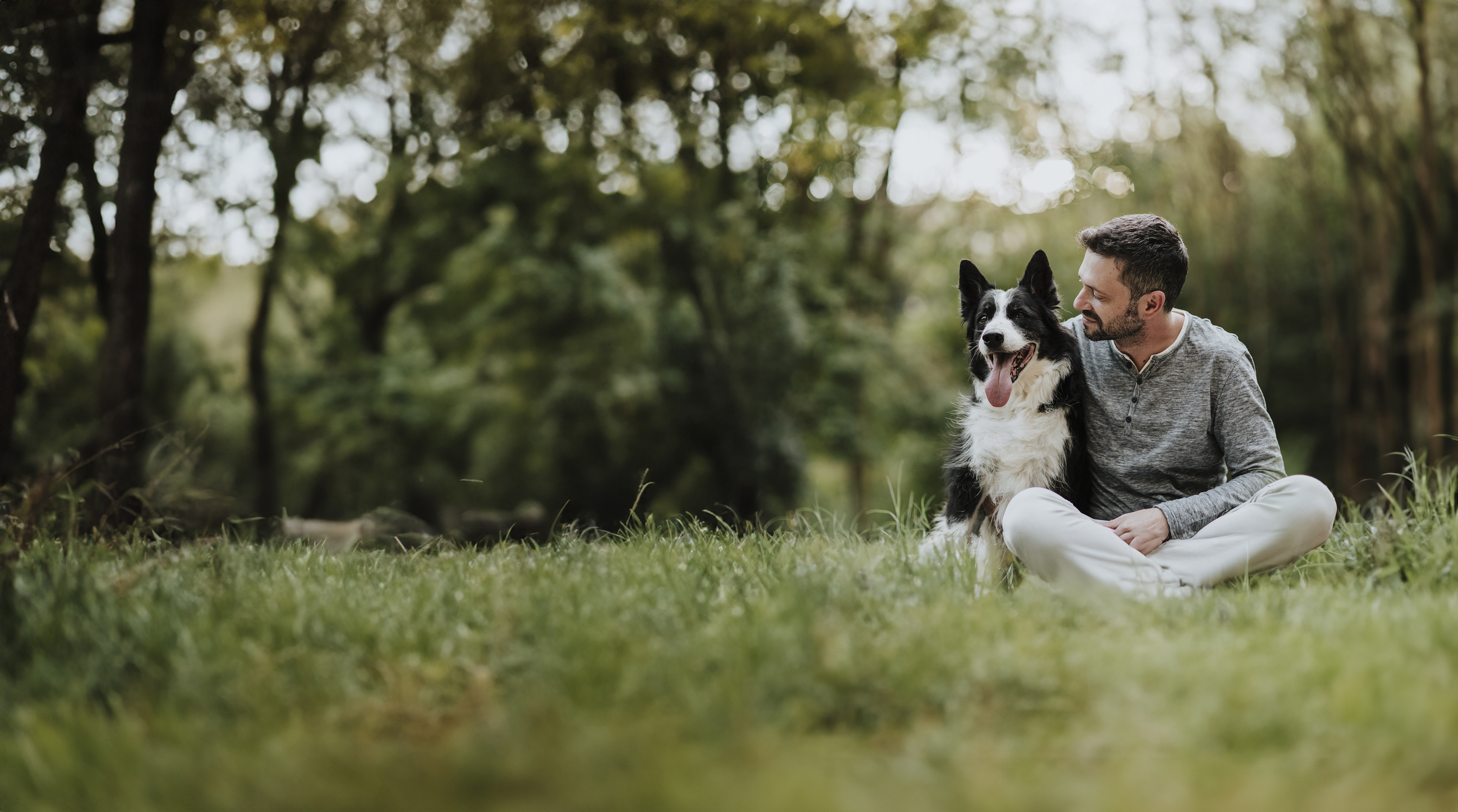 man sittng with dog on grass